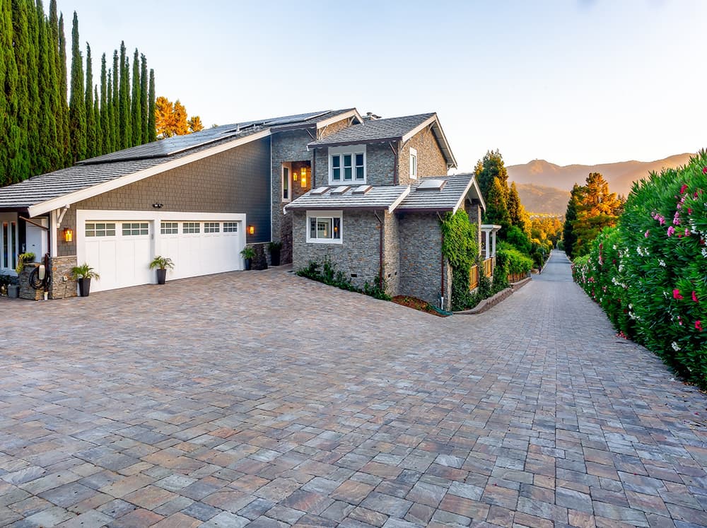 A large driveway paved with neutral-tone concrete pavers.